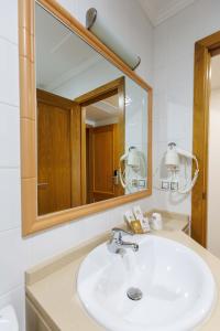 a bathroom with a sink and a mirror at Hotel O Cruceiro in Caldas de Reis
