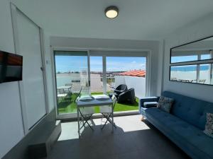 a living room with a blue couch and a table at Adosado privado playa in San Antonio
