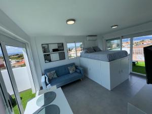 a bedroom with a bed and a couch and windows at Adosado privado playa in San Antonio