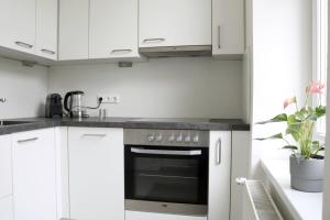 a kitchen with white cabinets and an oven at Apartment Two am Stadtpark in Villach +7 photos