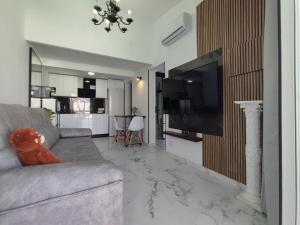 a living room with a couch and a flat screen tv at Bungalow privado junto al Yumbo Centre in San Bartolomé de Tirajana