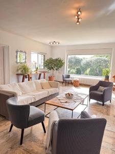 a living room with a white couch and chairs at La Marjalou à Vence avec piscine & grand jardin in Vence