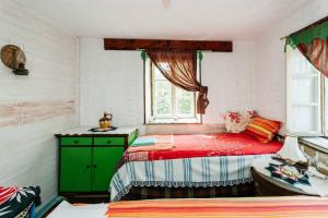 Un dormitorio con una cama roja y un armario verde. en Къща за Гости Марго, en Kosti