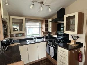 a kitchen with a sink and a stove top oven at New Hampton 36 in Dunoon