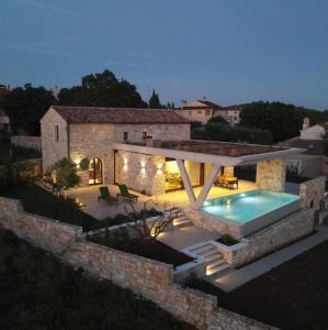 a villa with a swimming pool at night at Casa Farfalla in Bale