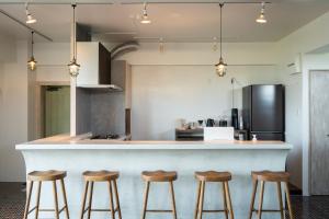 a kitchen with a counter and four stools at DESLIE - Vacation STAY 74346v in Sarahama