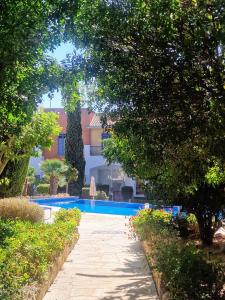 a swimming pool next to a building with trees at Viktoria Houses Anarita in Anarita