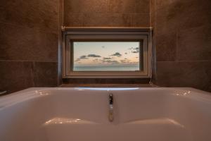 a bath tub in a bathroom with a window at DESLIE - Vacation STAY 74346v in Sarahama +62 photos