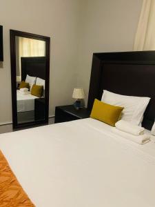 a bedroom with a large bed and a mirror at Palm Inn Boutique Palapye in Palatswe