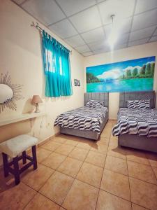 two beds in a room with a painting on the wall at Mamas Summer House in Larnaca +11 photos