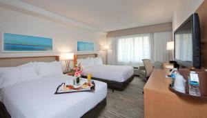 a hotel room with two beds and a flat screen tv at Holiday Inn Washington-Central/White House by IHG in Washington, D.C.