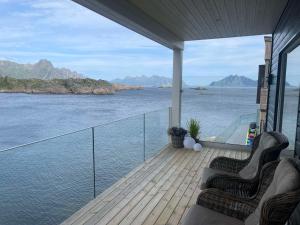 Un balcón con dos sillas y vista al agua. en Leilighet med høy standard og fantastisk havutsikt, en Kabelvåg