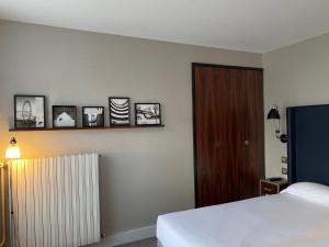 a bedroom with a bed and some pictures on the wall at Hôtel Londres et New York - Teritoria in Paris