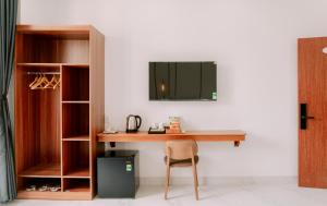 a desk with a chair and a mirror on a wall at Camellia Hotel Can Tho in Can Tho