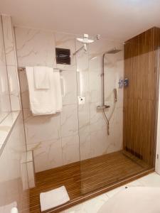 a shower with a glass door in a bathroom at Apartment HomeBase Modernes 4-Sterne Apartment mit Tiefgarage im Zentrum in Oberkochen