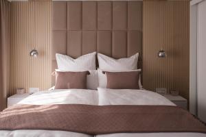 a bedroom with a large bed with white sheets and pillows at Apartment HomeBase Modernes 4-Sterne Apartment mit Tiefgarage im Zentrum in Oberkochen
