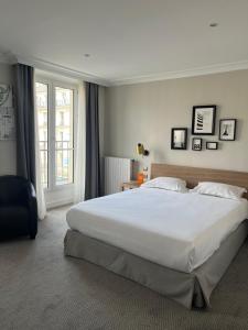a bedroom with a large white bed and a window at Hôtel Londres et New York - Teritoria in Paris