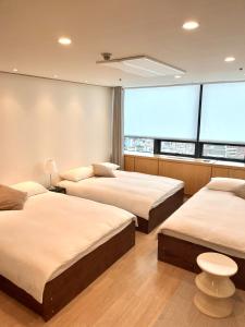 a bedroom with two beds and a large window at NewsenseB-1sec from Hongdae Sub&wifi in Seoul