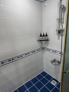 a bathroom with a shower with a blue tiled floor at NewsenseB-1sec from Hongdae Sub&wifi in Seoul