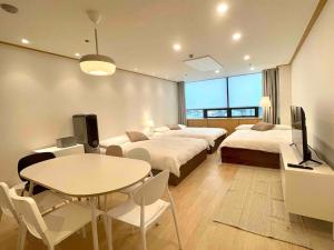 a hotel room with two beds and a table and a tv at NewsenseB-1sec from Hongdae Sub&wifi in Seoul +6 photos