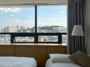 a bedroom with a large window with a view of a city at NewsenseB-1sec from Hongdae Sub&wifi in Seoul
