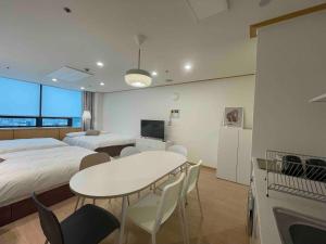 a hotel room with two beds and a table and chairs at NewsenseB-1sec from Hongdae Sub&wifi in Seoul