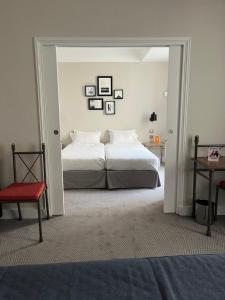 a bedroom with a large bed and a red chair at Hôtel Londres et New York - Teritoria in Paris