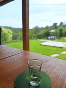 a glass on a green plate on a wooden table at Jos 5 minuta in Jagodina