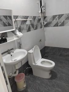a bathroom with a toilet and a sink at MUINE MOMO Homestay in Ấp Khánh Phước (1)