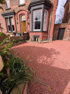 a brick house with a front porch and a driveway at Merchant House in Bootle