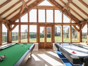a room with two pool tables and windows at The Barn in York
