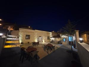 a patio with tables and chairs at night at Evra Cappadocia Hotel in Nevşehir