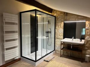 a bathroom with a glass shower and a sink at Chateau de la Vieille Chapelle in Lugon et l’Ile du Carney
