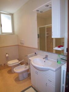 a bathroom with a sink and a toilet and a mirror at Casa Lory in Marone