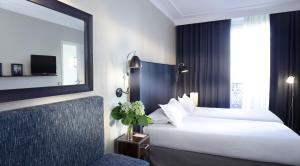 a hotel room with a large bed and a mirror at Hôtel Londres et New York - Teritoria in Paris