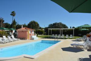a swimming pool with chairs and a pavilion at SOLAR DOS AVÓS in Guia