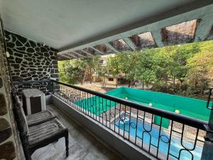 a balcony with a bench and a swimming pool at Blue Heaven- Lonavala 2 Bhk with private pool! in Lonavala
