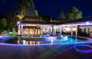 a group of people sitting in a pool at night at Apartman De Lux in Nyíregyháza