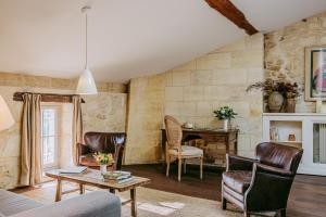 a living room with leather chairs and a table at Logis de la Cadène in Saint-Émilion