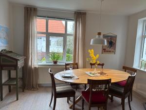 a dining room with a table and chairs and a window at Garden Apartment by the Sea in Sønderborg