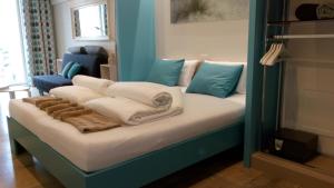 een bed met witte lakens en blauwe kussens erop bij Kabine 7 in Koksijde +18 foto's