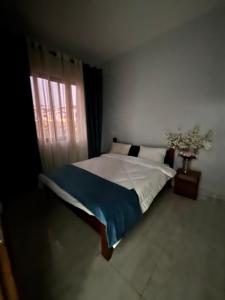 a bedroom with a large bed with a window at ISARO Estate in Kigali
