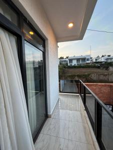 a balcony with glass doors and a view at ISARO Estate in Kigali +4 photos