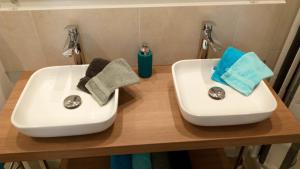 twee witte wastafels op een houten aanrecht in een badkamer bij Kabine 7 in Koksijde