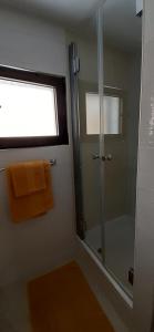 a bathroom with a shower and a window and a towel at Old Town Baska in Baška