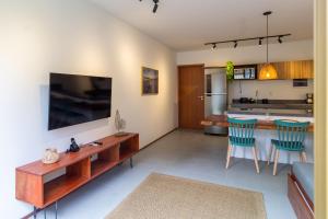 a living room with a table and a kitchen at Villa Naluri - Casa Yodo - Apartamento 1 quarto em Japaratinga in Japaratinga