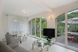 a living room with a couch and a tv at Loggia Oliveto in Casanova Lerrore