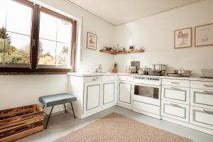 a kitchen with white cabinets and a window at Ferienhaus Tannenblick Rochlitz in Rochlitz +53 photos