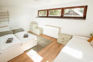 a white room with two beds and a couch at Ferienhaus Tannenblick Rochlitz in Rochlitz