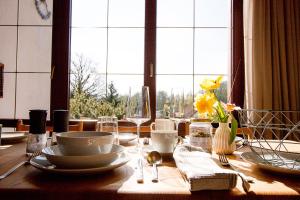 a table with plates and dishes on it with a window at Ferienhaus Tannenblick Rochlitz in Rochlitz